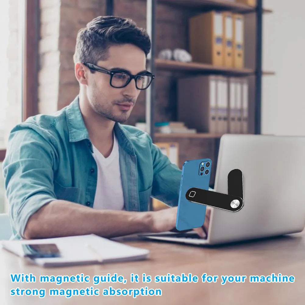 Black aluminium magnetic phone holder attached to side of silver laptop