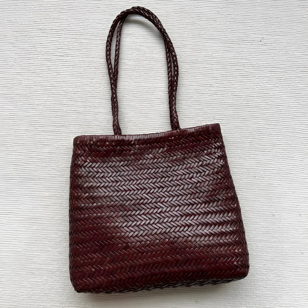 Woven vintage cowhide leather tote bag with three-dimensional outer pockets showing brown colour
