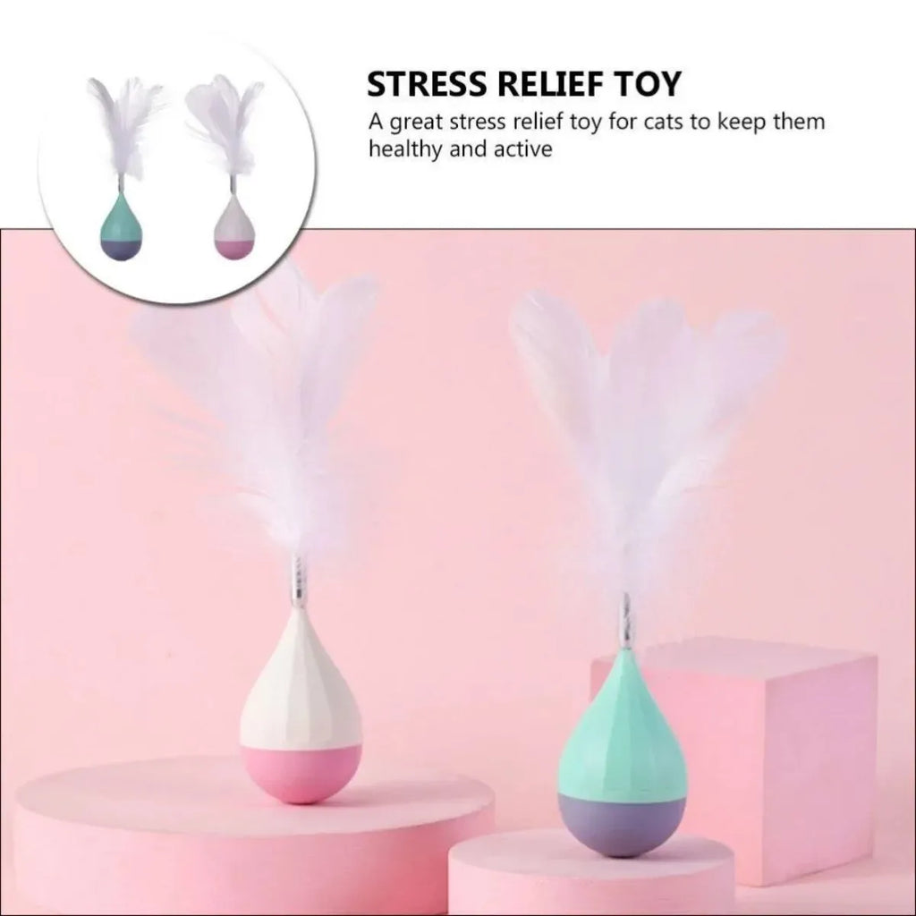 Green feather tumbler cat toy with goose feathers and aluminium alloy components on wooden floor