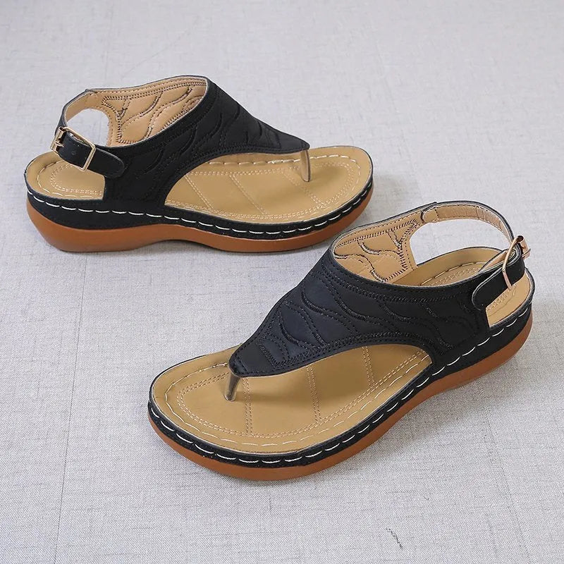 Women's wedge heel sandal in a solid colour with an adjustable back strap buckle.