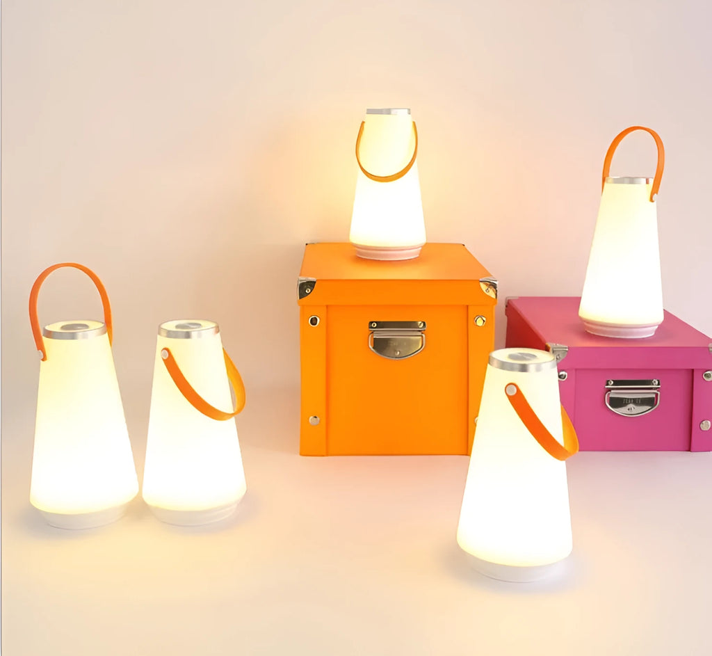 White rechargeable LED table lamp with USB cable on a wooden surface.