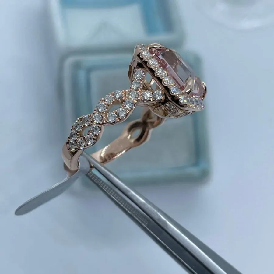 Geometric rose gold alloy ring on a plain background, showing its angular shape and metallic finish.
