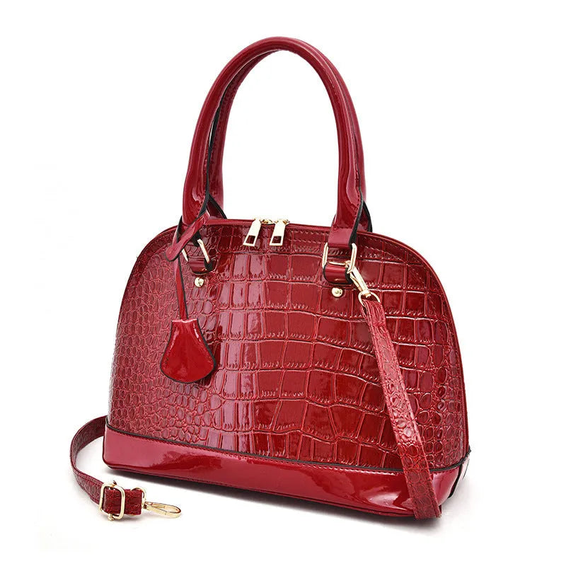 Large shiny black PU leather crossbody bag with structured shell shape design.