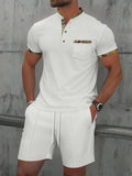 Man wearing a grey short sleeve zippered polo top and matching shorts, a casual cotton blend suit set.