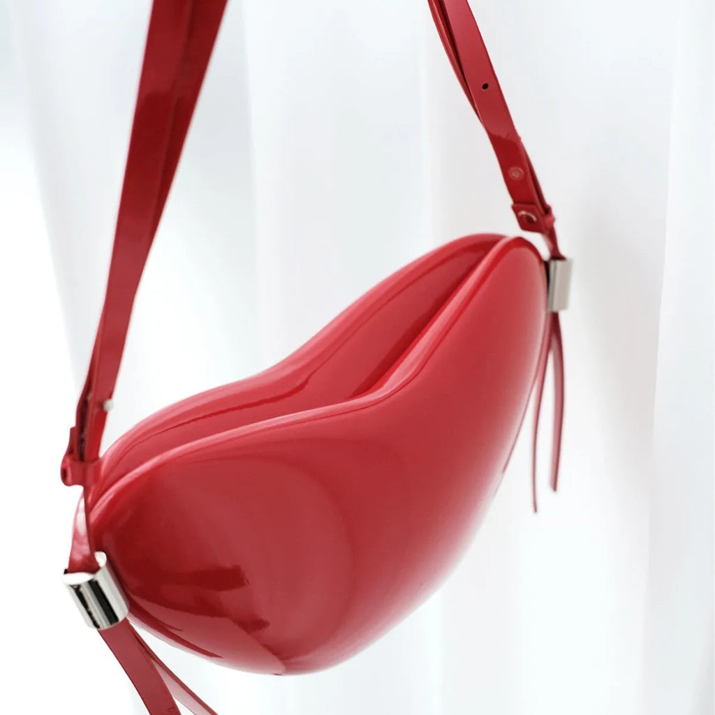 Red heart shaped crossbody bag in solid PU synthetic leather with single shoulder strap and sandwich pocket