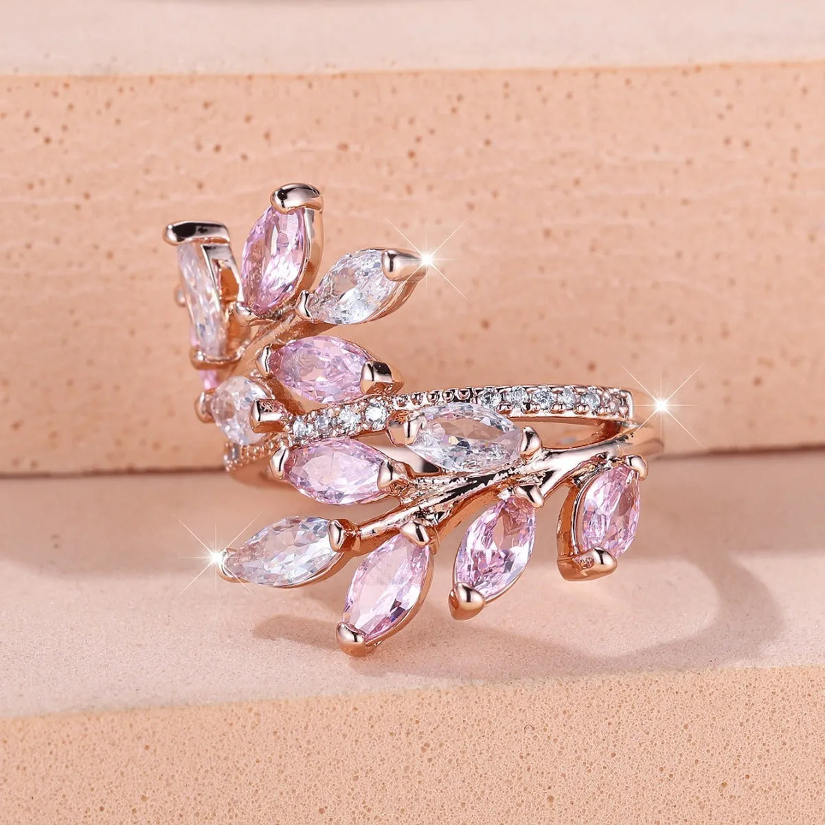 Adjustable leaf ring with horse eye zircon stone in rose gold finish on wooden background