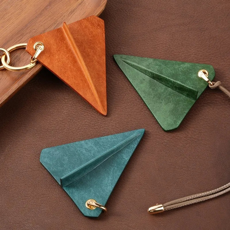 Crazy Crafts handmade cowhide paper airplane pendant in brown, on a bag