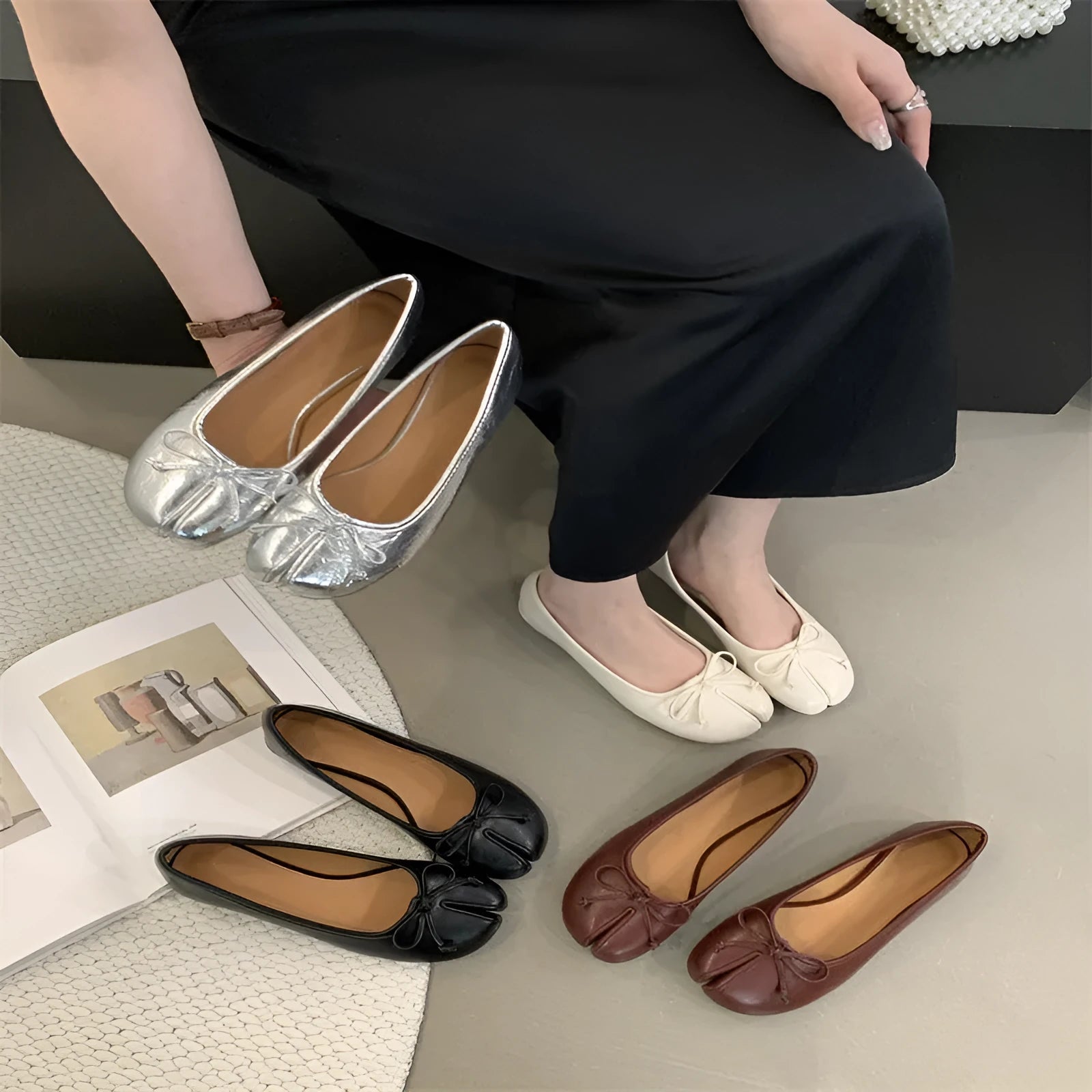 Women's black split-toe flat pumps with a round toe and slip-on oversleeve design.