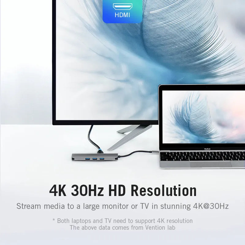 Deep grey aluminium USB-C multi-port hub showing HDMI, USB, Ethernet, and memory card ports on a desk