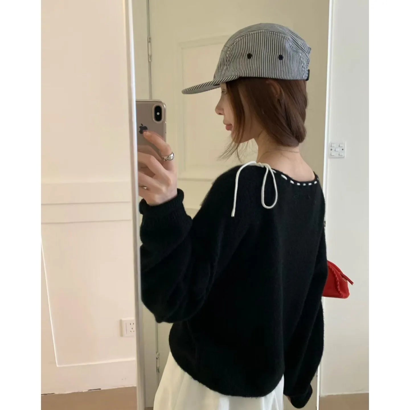 Grey loose-fitting women's pullover sweater made from regenerated cellulose knitwear on a hanger.
