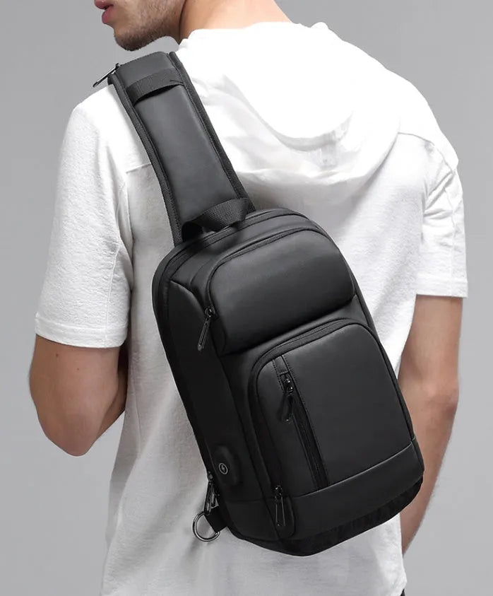 Black PVC medium-sized shoulder bag with air cushion strap and soft handle.