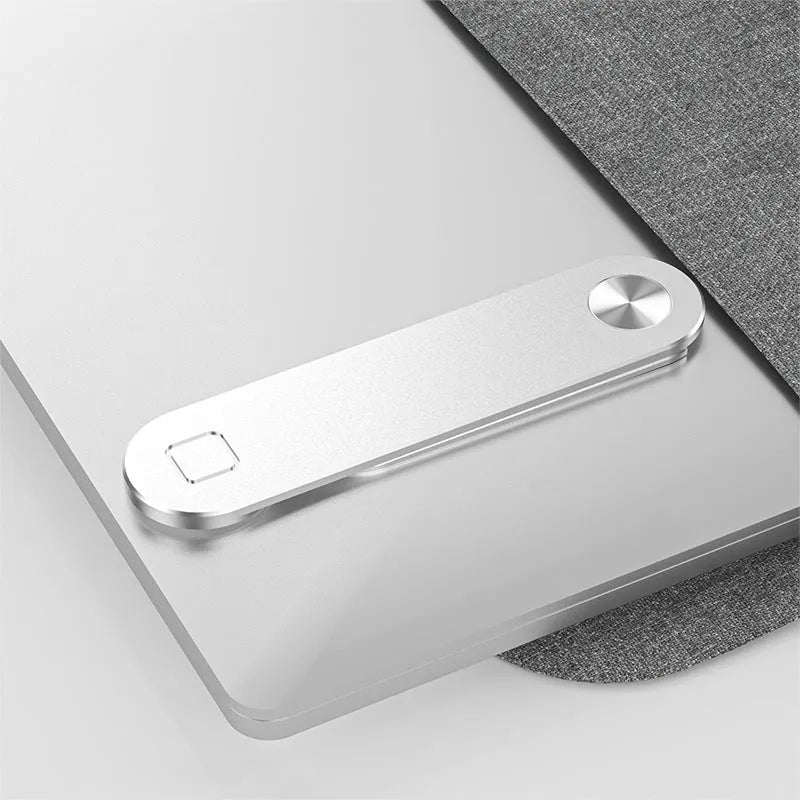 Black aluminium magnetic phone holder attached to side of silver laptop