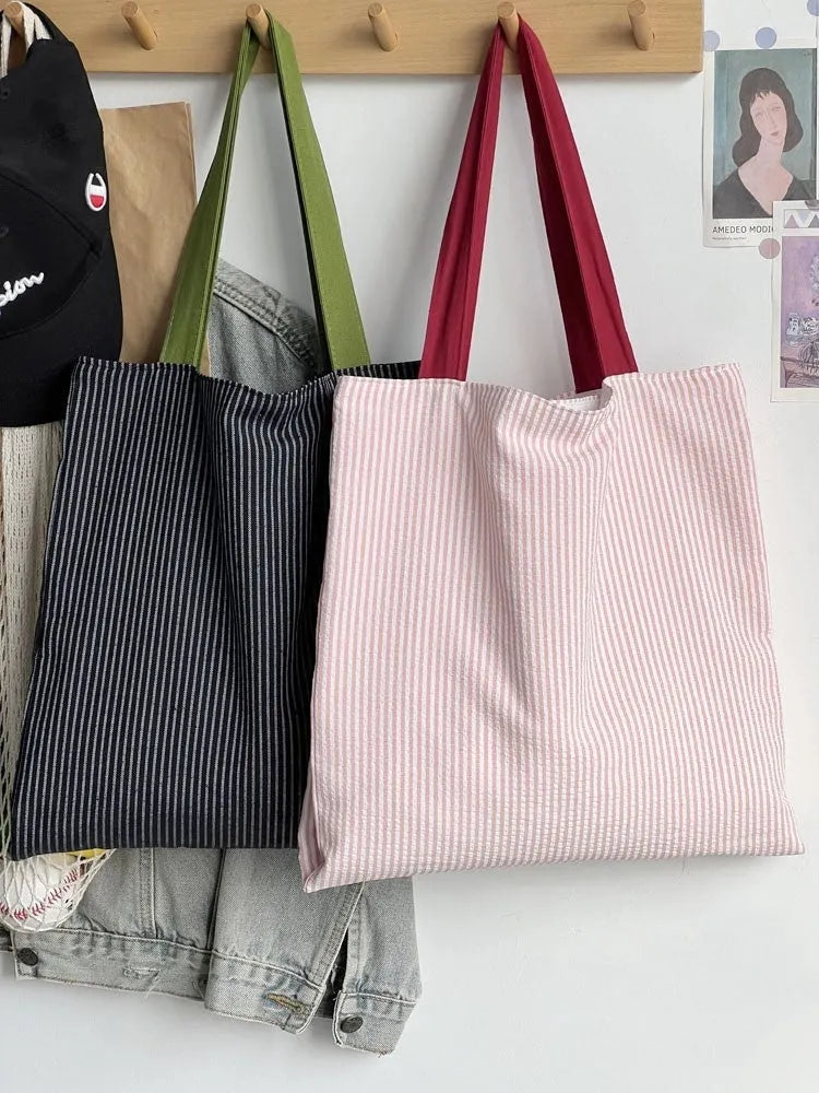 Casual multi-layer canvas tote shoulder bag in a plaid pattern with a wide strap.