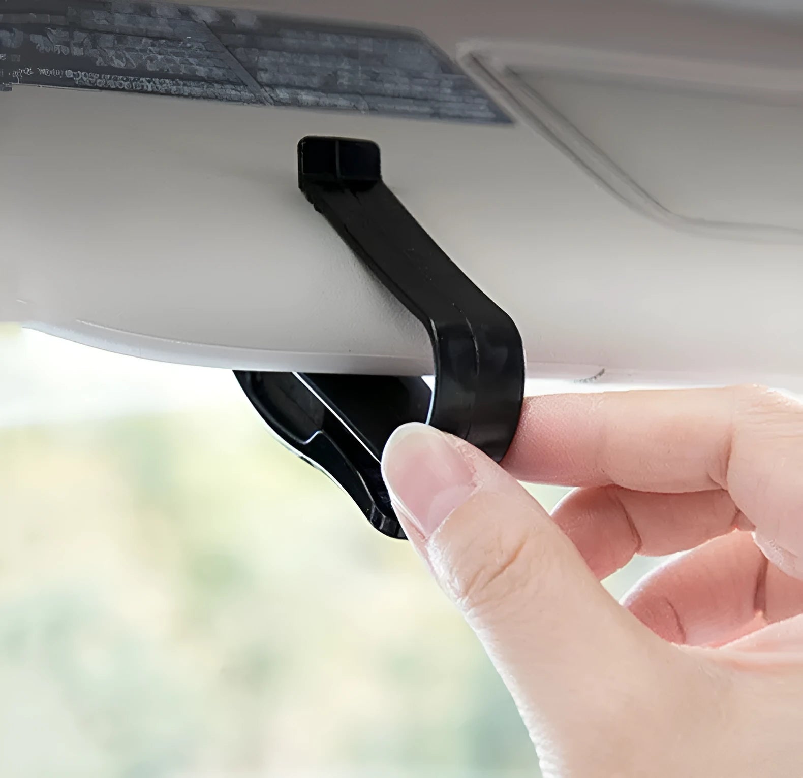 Black plastic clip for car sunshade to hold sunglasses and cards, dimensions 6.5 by 2.3 cm.