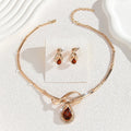 Gold alloy necklace and earrings set with white rhinestone and brown crystal inlay, V-shaped pendant, fishtail fan design