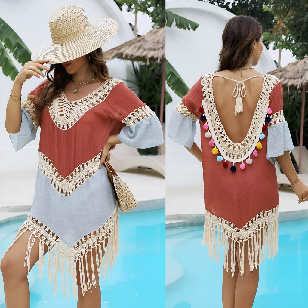 Orange floral pattern beach overskirt with hand crochet detail and tassels, laid flat.