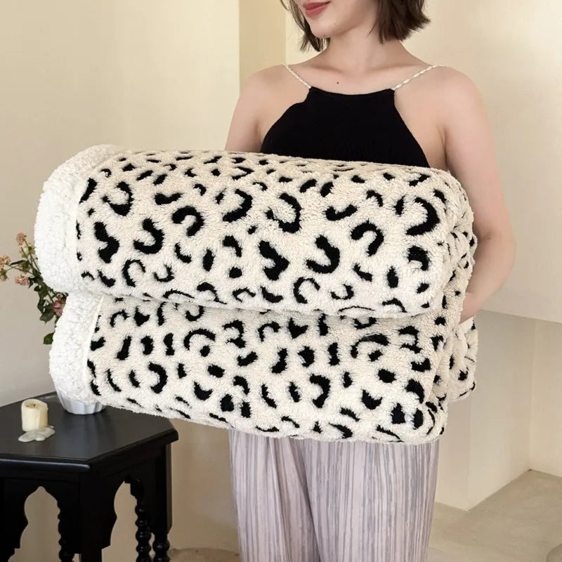 Double-layer jacquard taffeta blanket with leopard print pattern in a camel colour, laid flat on a bed.