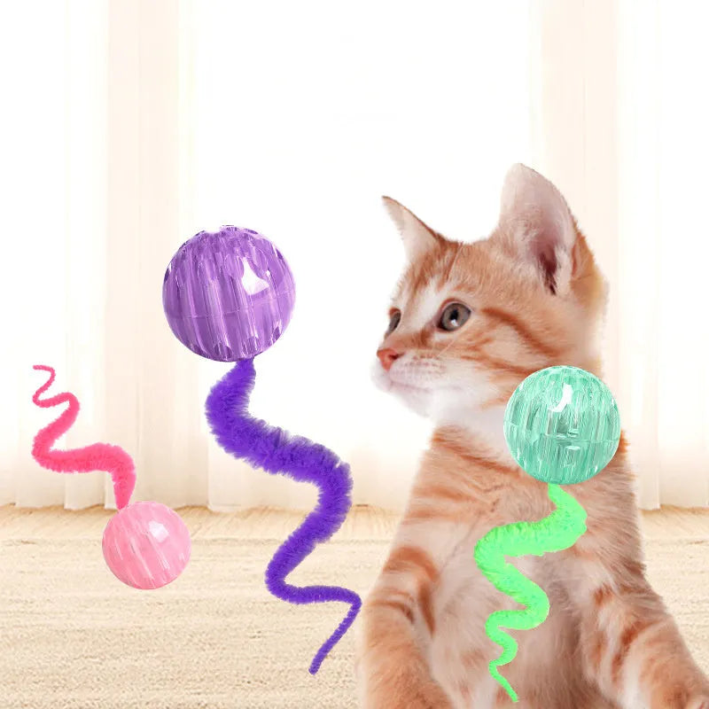 Interactive cat ball toy with elastic worm tail in green colour on wooden floor