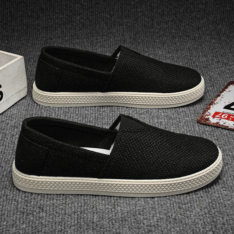 Men's beige canvas slip-on shoes with round toe and PVC sole on a plain background