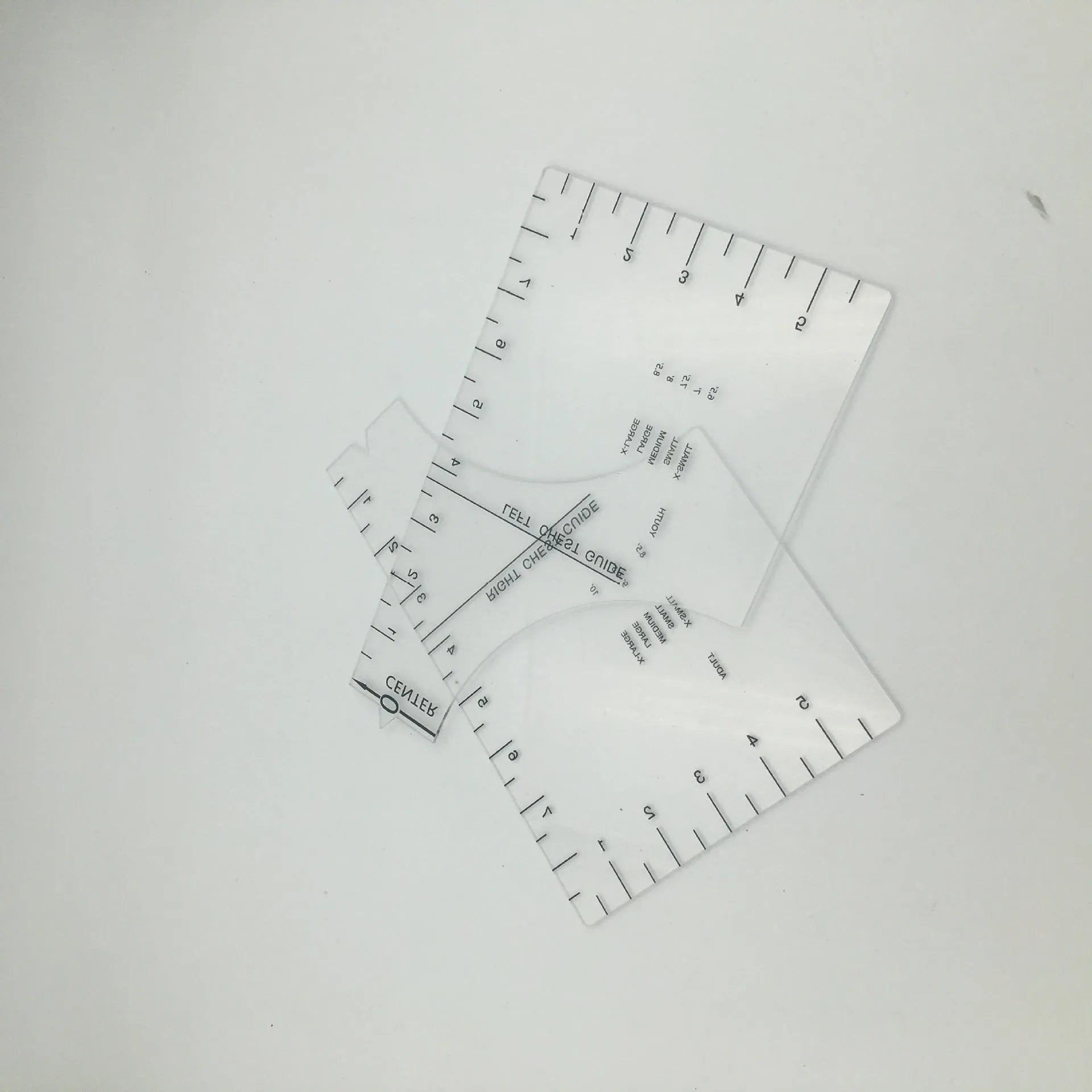 Transparent acrylic sewing ruler for aligning T-shirt designs, measuring 10 by 6 inches.