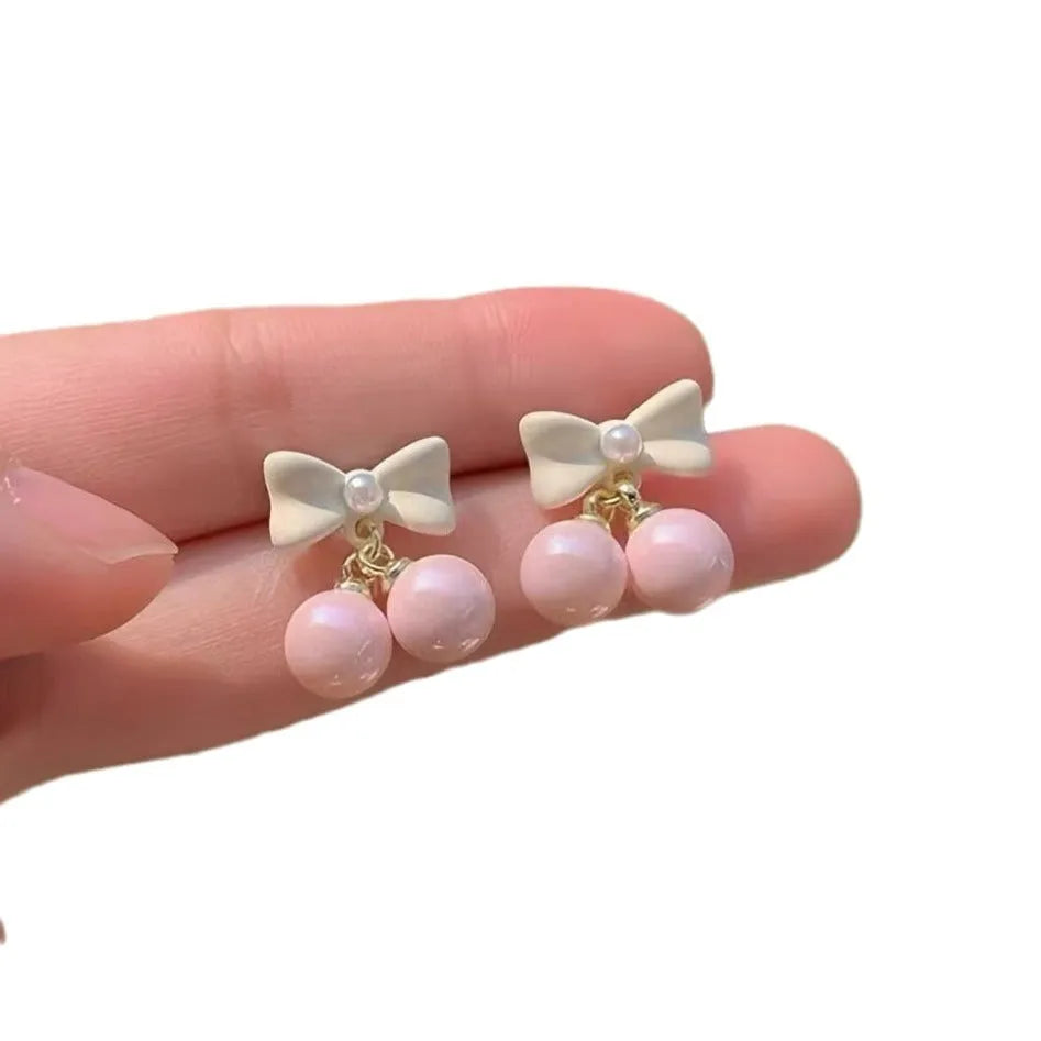Pink alloy women's earrings with heart, pearl, and bow design, electroplated finish, sold as one pair