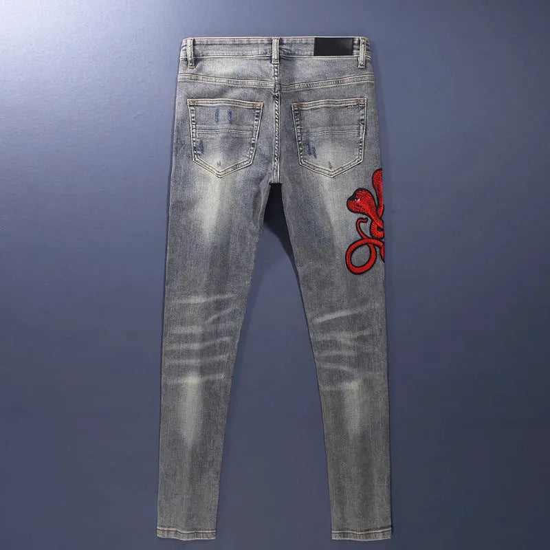 Men's slim fit distressed jeans with embroidered patches in old colour wash