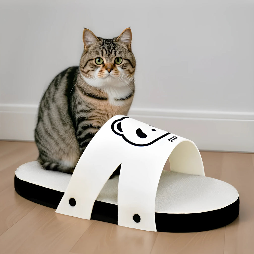 White corrugated paper cat scratch board in a slipper shape on a floor.