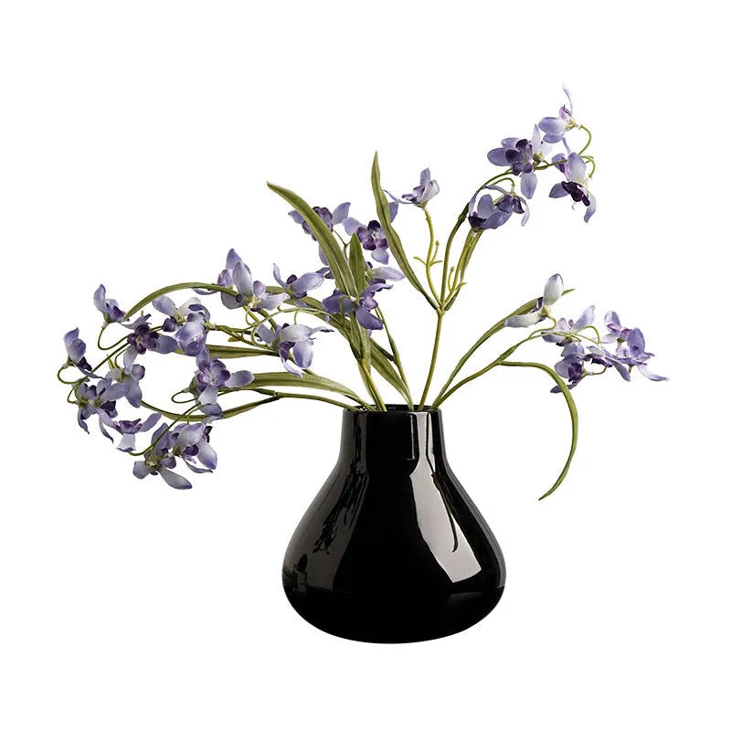 Black and white ceramic round belly french style decorative vase with two artificial flowers.