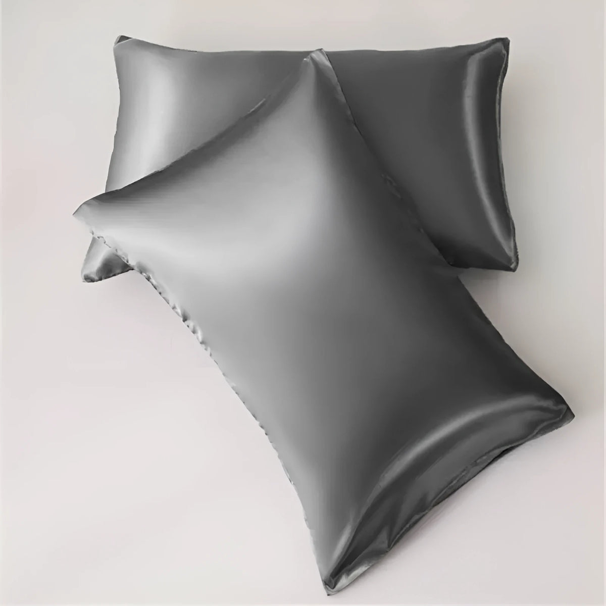Dark blue polyester satin pillowcase with envelope closure on a bed