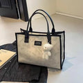 Women's black canvas tote bag with rhombus print pattern and shoulder strap