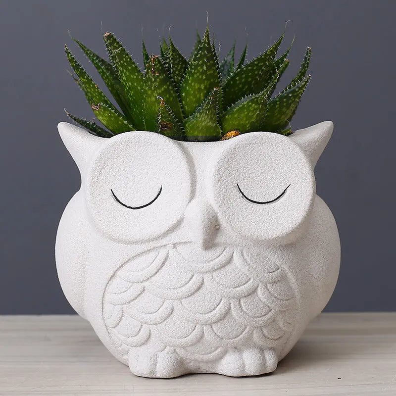 Handmade frosted ceramic flower pot with a cartoon owl design, shown in light pink.