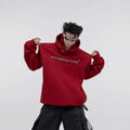Men's loose grey hooded sweater with metallic graphic print and structured shoulder pads on a hanger.