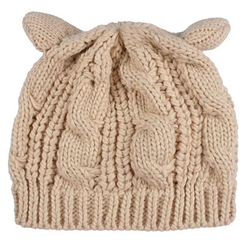 Hand made red knitted beanie hat with 3D cat ears on a white background