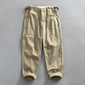 Men's straight-leg cotton casual trousers in apricot colour on a hanger