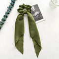 Dark green fabric large intestine coil hair ring for women, shown wrapped around a ponytail.