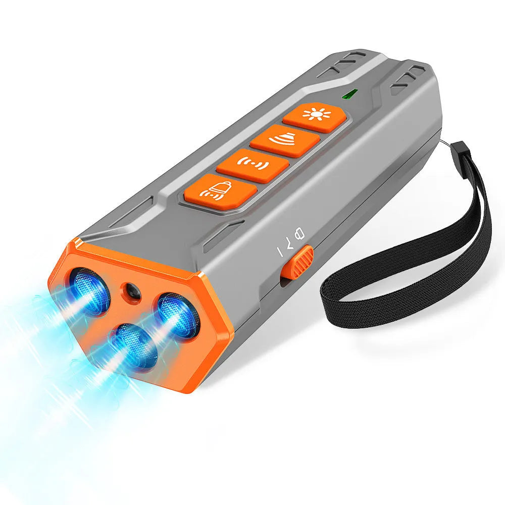 Grey and orange three-head ultrasonic dog trainer with remote control on a table.