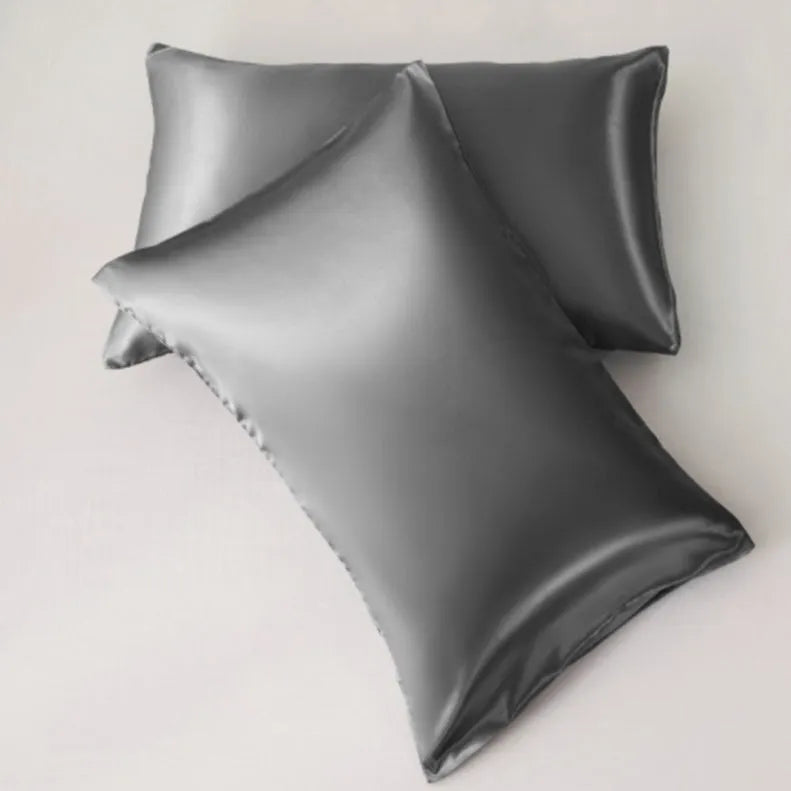 Dark blue polyester satin pillowcase with envelope closure on a bed