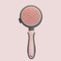 Green and pink dual-sided pet brush showing slicker brush side and silicone massage head side