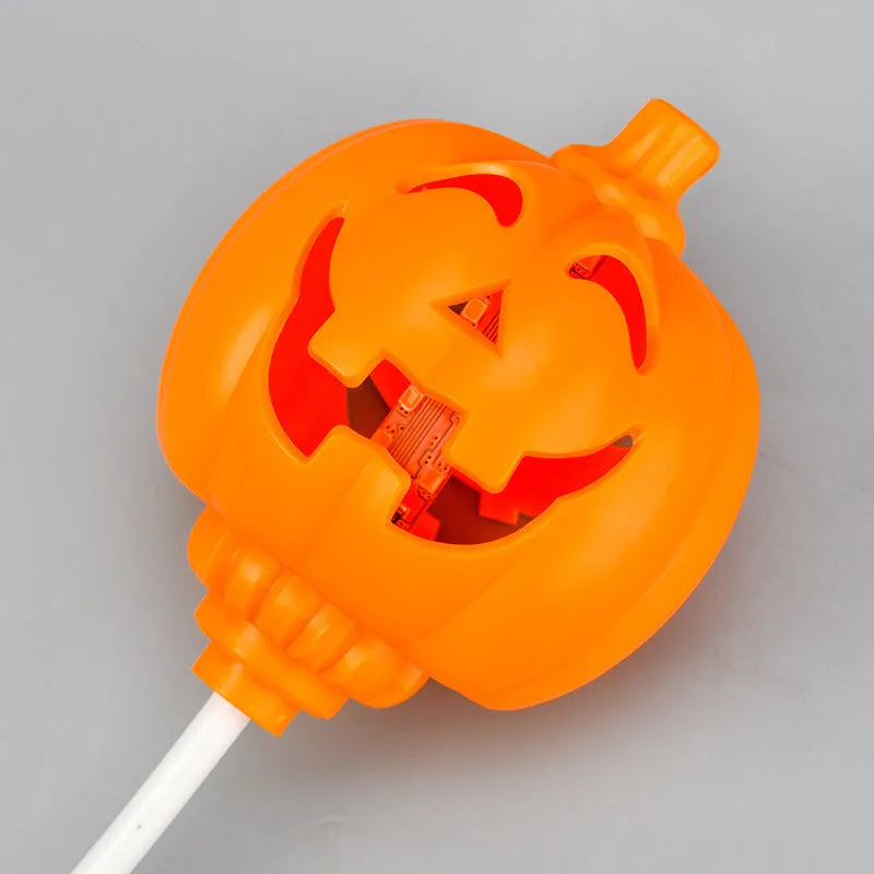A plastic pumpkin lamp with a USB port, glowing in either yellow or purple light.