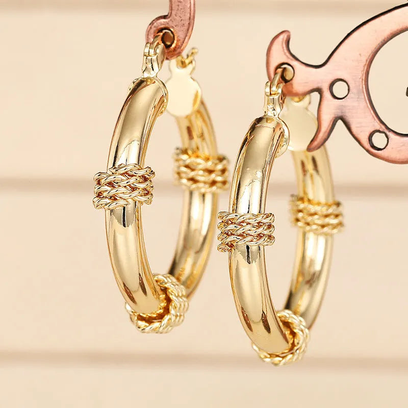 Golden geometric clip-on earrings with ring and line design elements