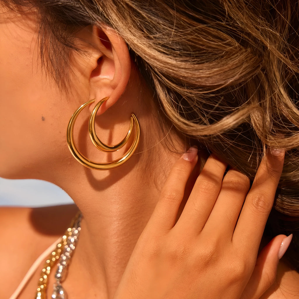 Simple round titanium steel hoop earrings for women in gold and steel finishes, shown in small and large sizes.