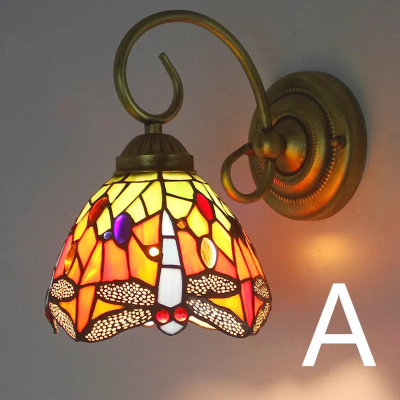 A coloured stained glass wall lamp mounted on a corridor wall, showing one of six available style variants.