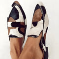 Women's black and white apricot retro pointed-toe flats with animal print suede upper and low heel.