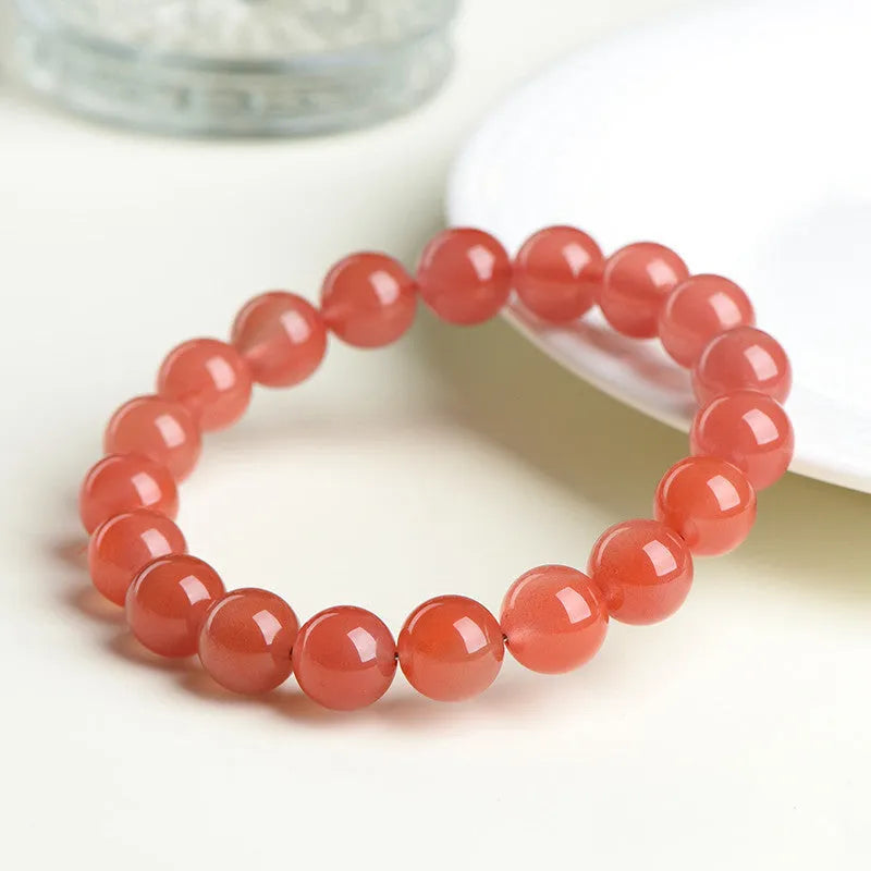 Natural cherry red agate beaded bracelet with polished round stones on a string.