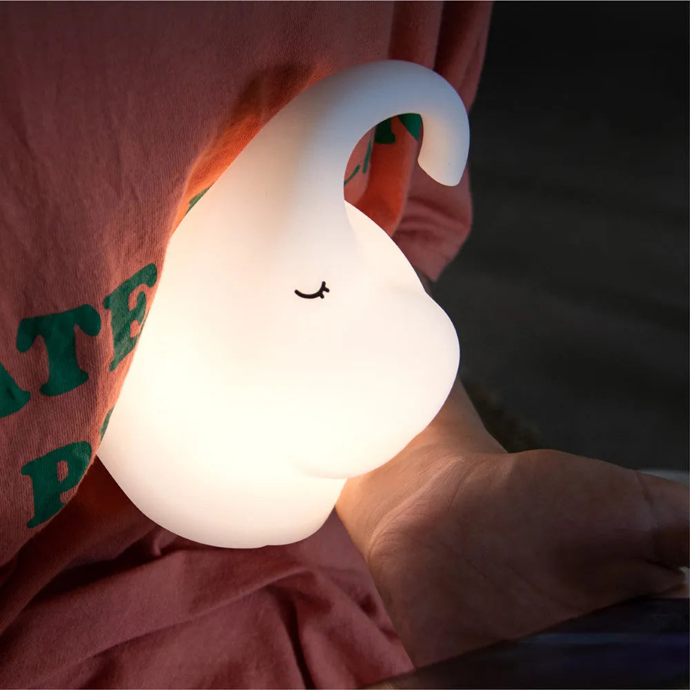 DOMI Elephant-shaped silicone USB night light with warm white glow on a bedside table.