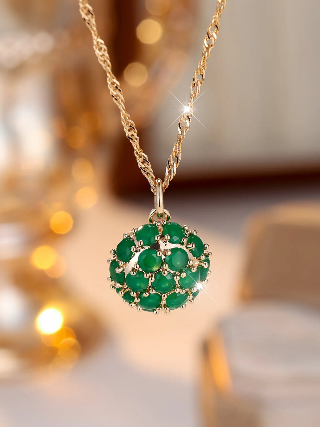 Round emerald pendant necklace with diamond surround on champagne gold chain