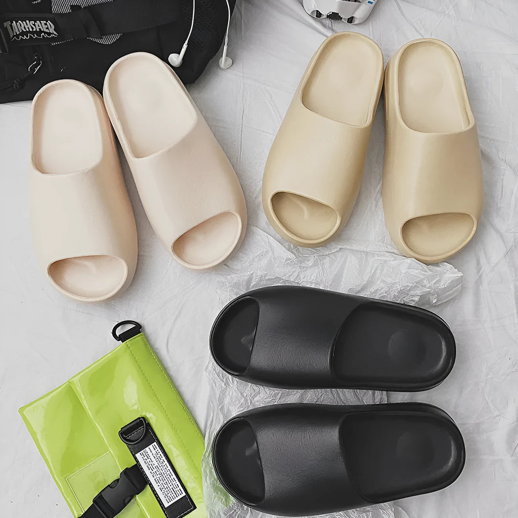Women's thick-soled beach slippers in beige, black, brown, and green on a summer background.