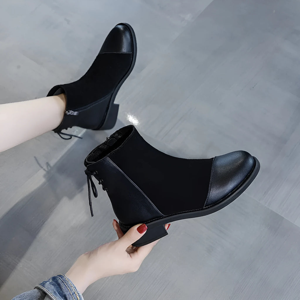 Black women's knee-high Martin boots with side zip, round toe, decorative bow, and rubber sole.