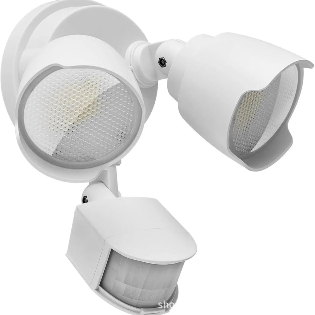 White outdoor LED flood light with motion sensor mounted on wall