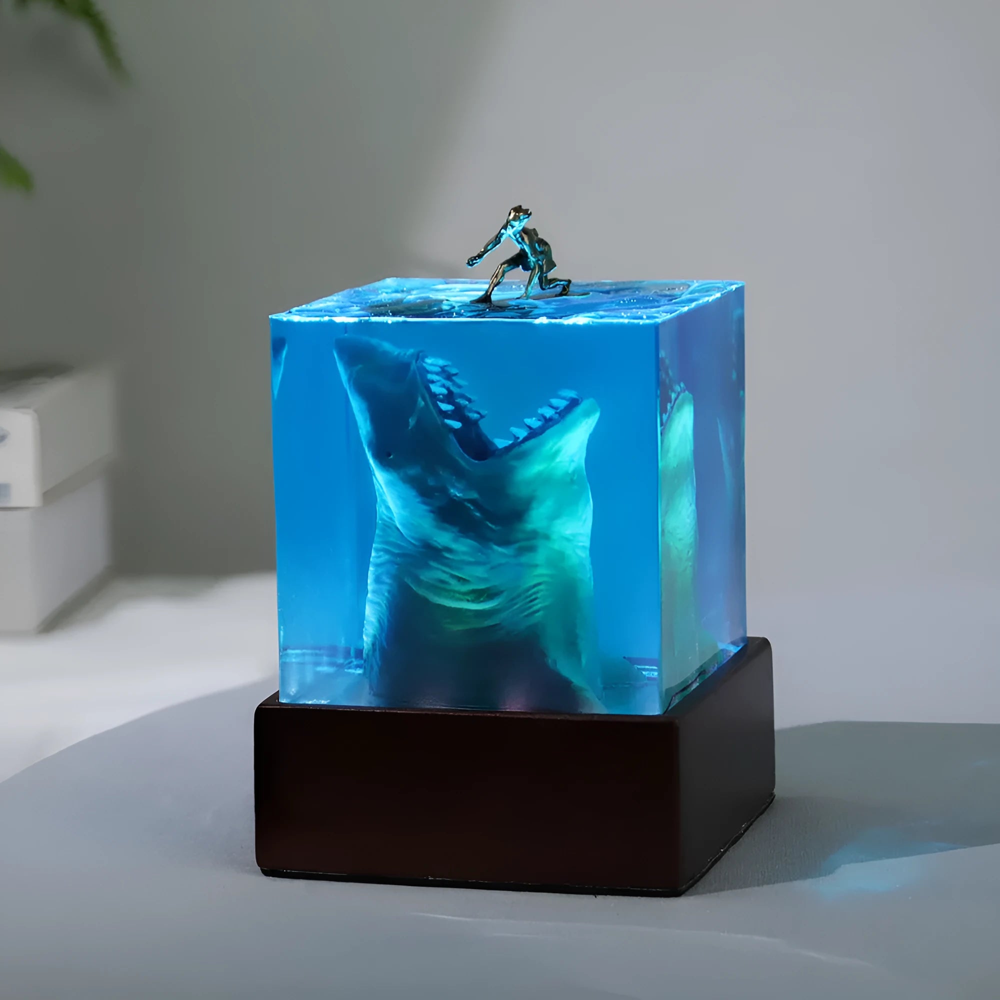 Clear epoxy resin ornament showing shark surfing on wave with integrated night light